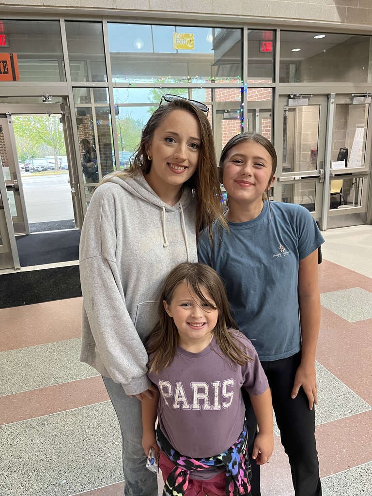 An adult and two children pose for a photo.