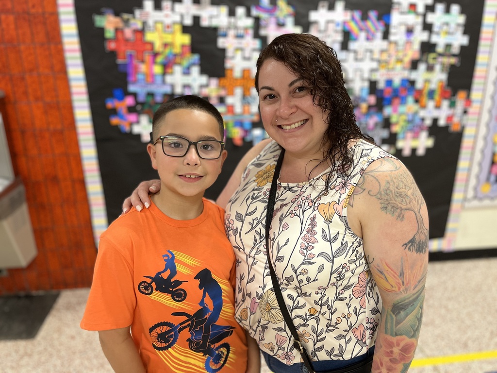 An adult and child pose for a photo.
