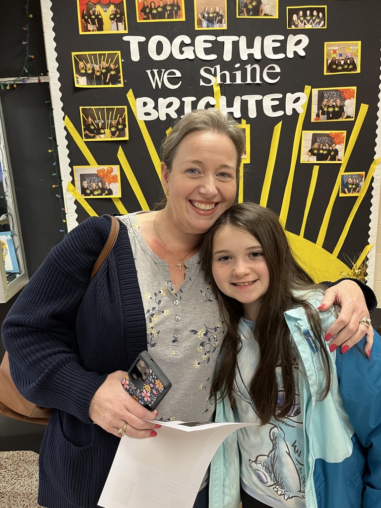 An adult and child pose for a photo.
