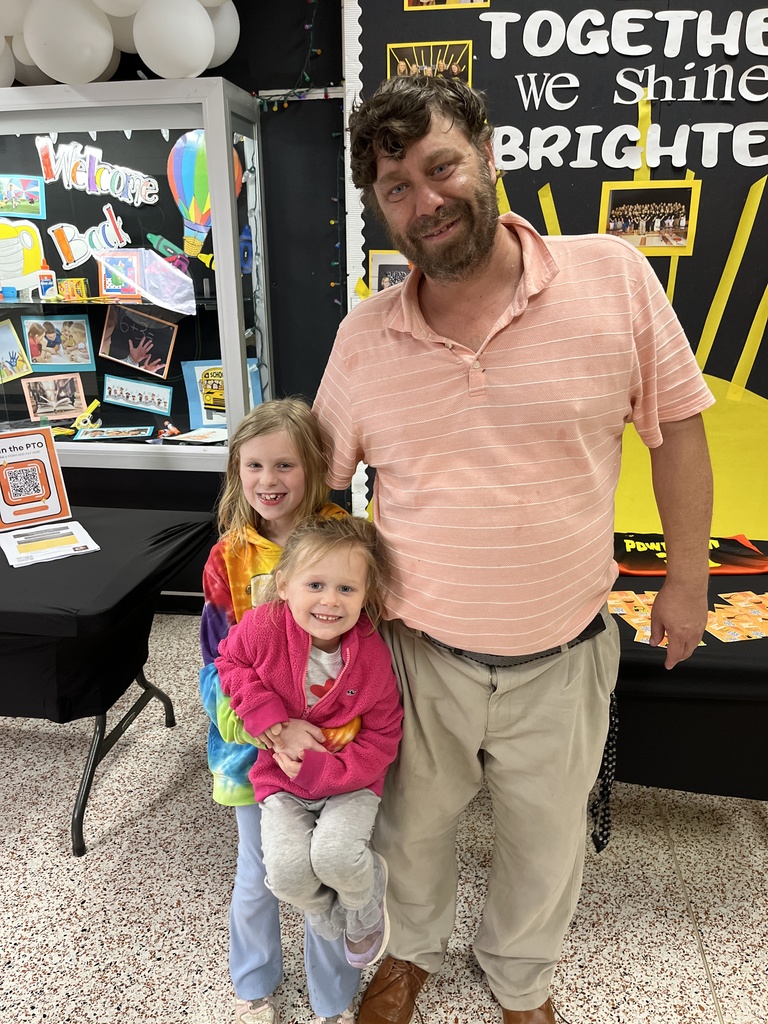 An adult and two children pose for a photo.