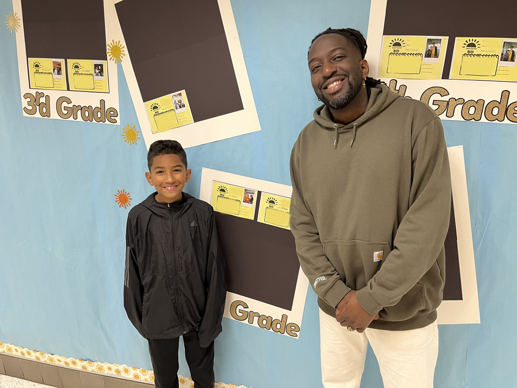 An adult and child pose for a photo. 