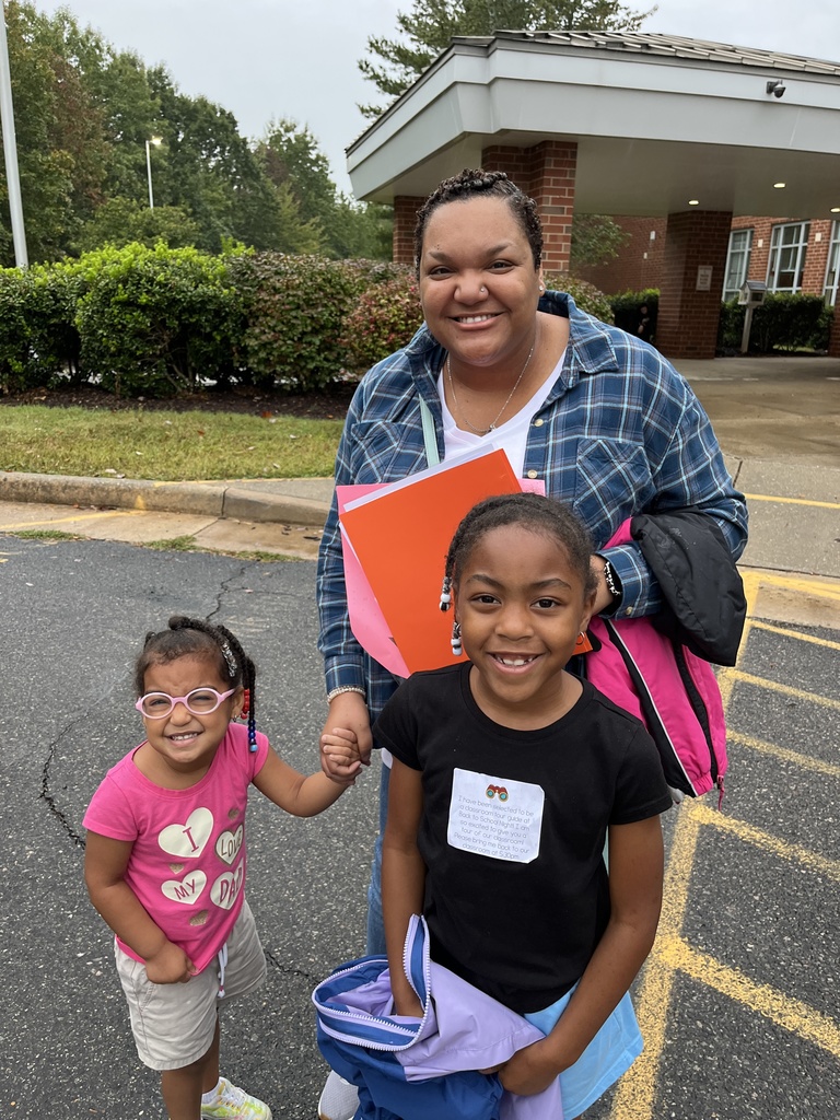 An adult and two children pose for a photo. 
