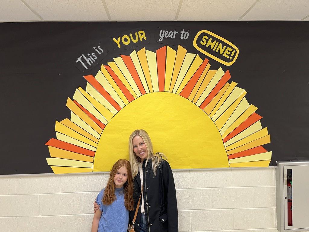 An adult and child pose for a photo. 