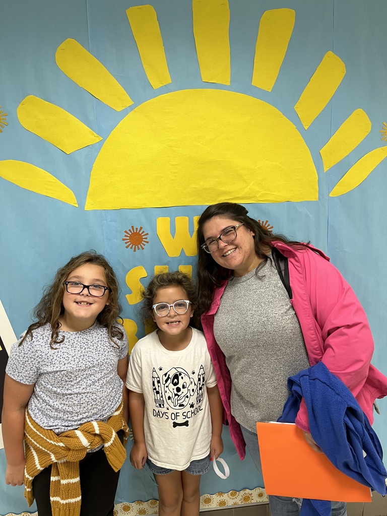 An adult and two children pose for a photo. 