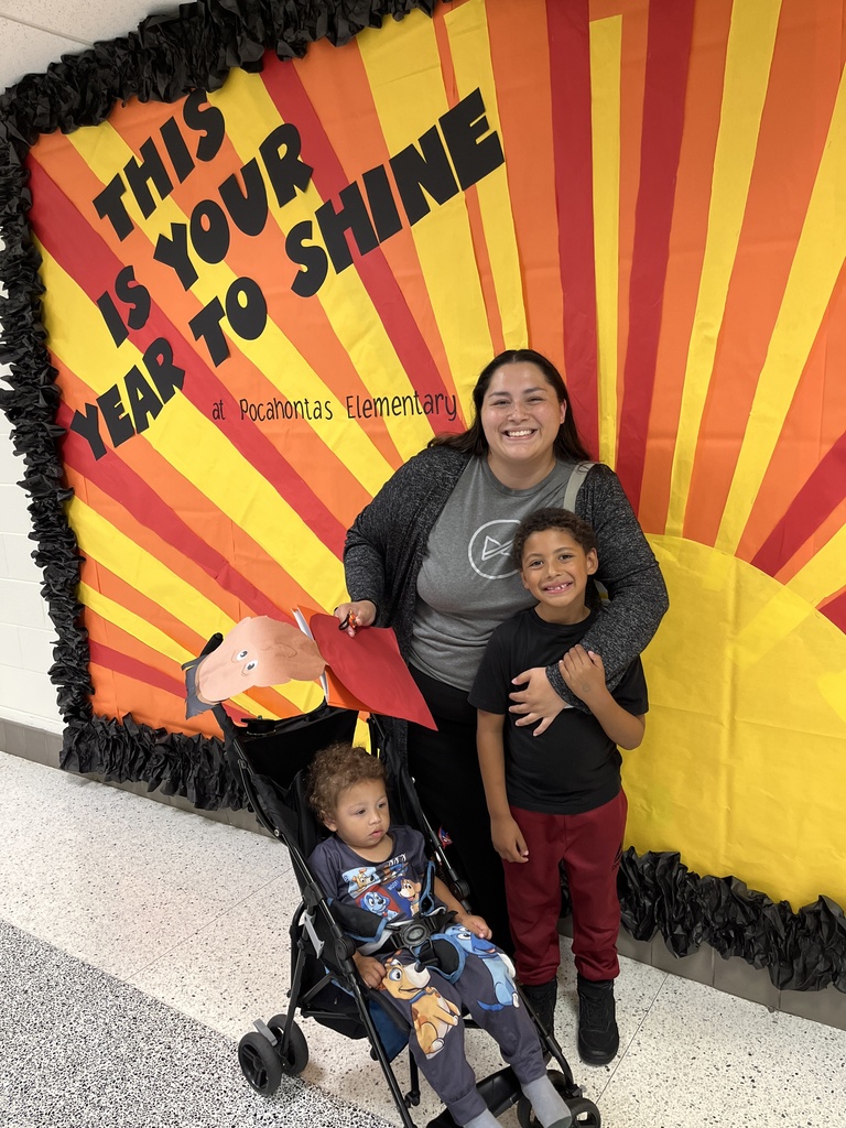An adult and two children pose for a photo. 
