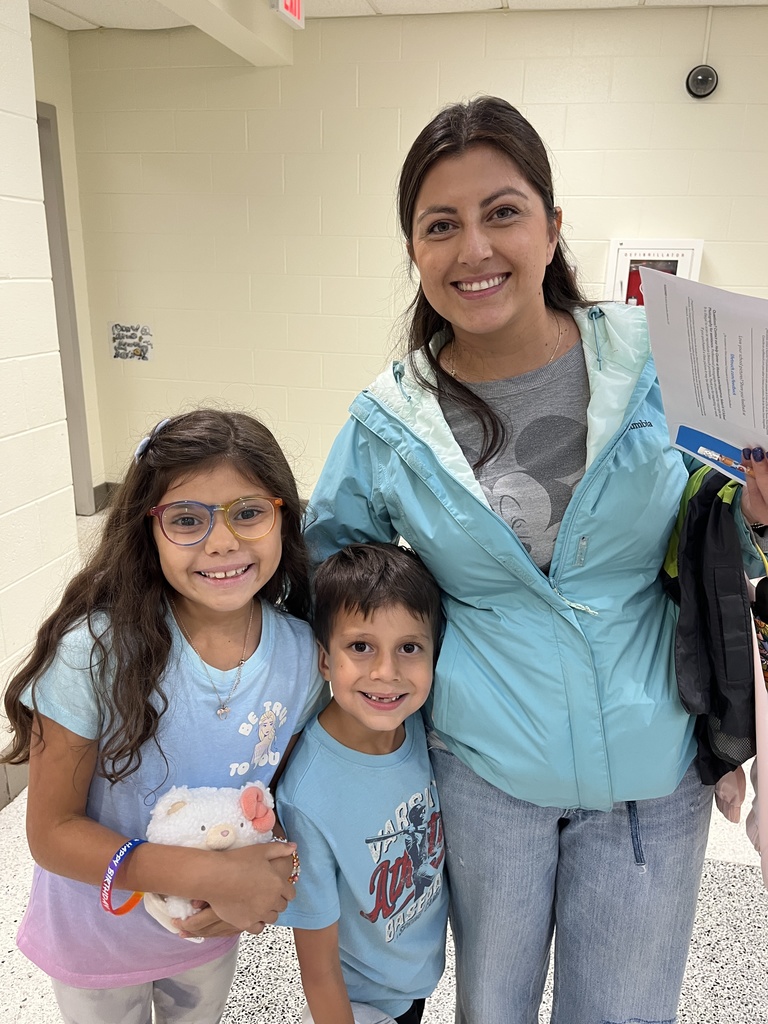 An adult and two children pose for a photo. 
