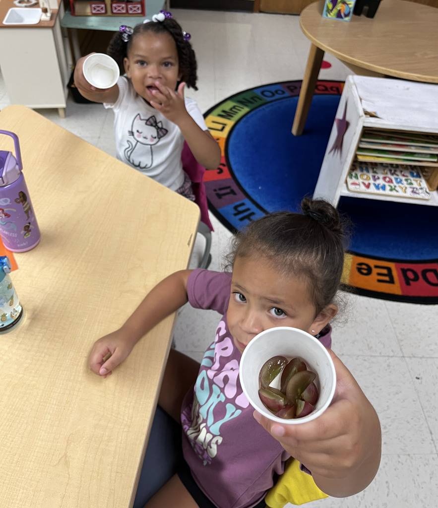 Preschoolers enjoy grapes as the snack for purple day.