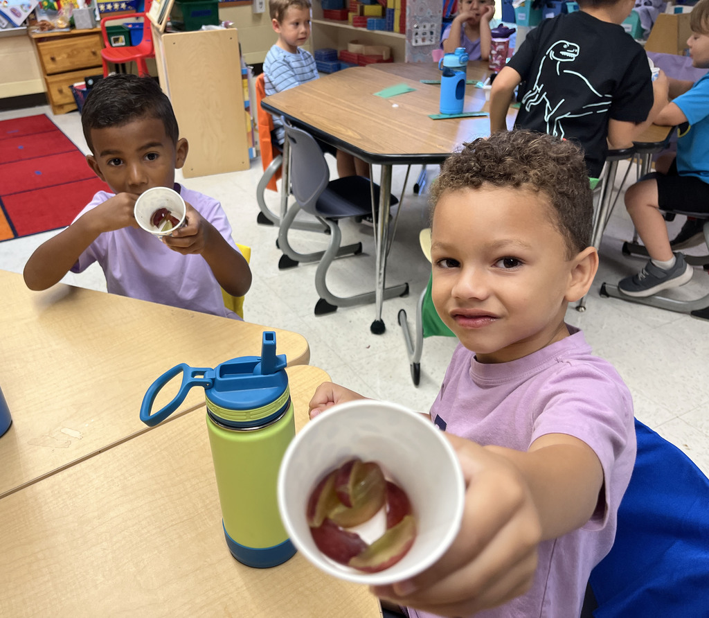 Preschoolers enjoy grapes as the snack for purple day.