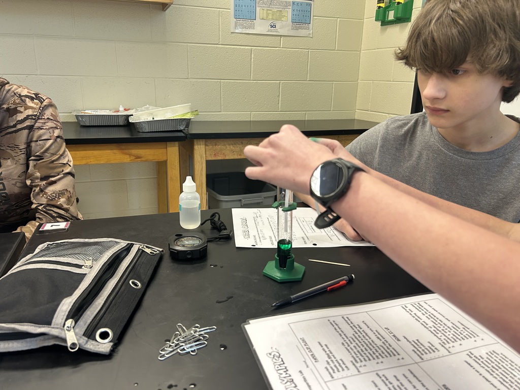 Students participate in a water experiment in biology class. 
