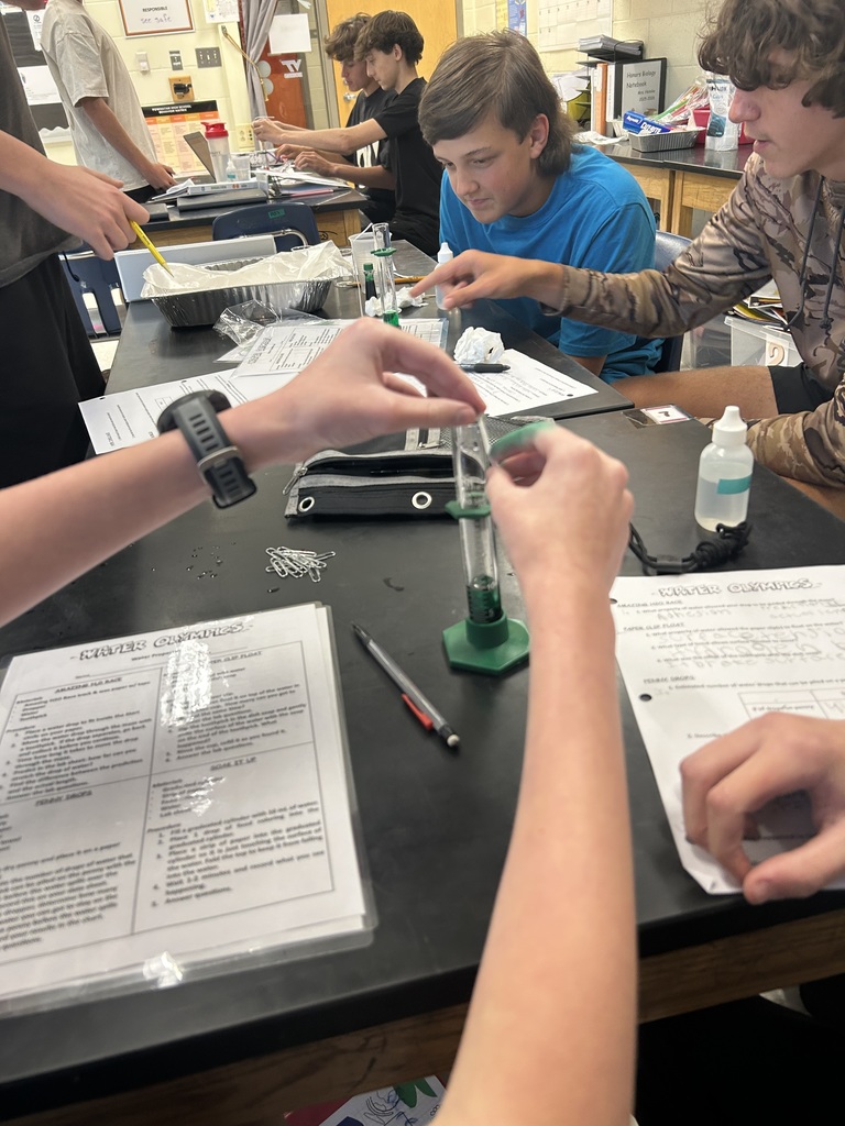Students participate in a water experiment in biology class. 