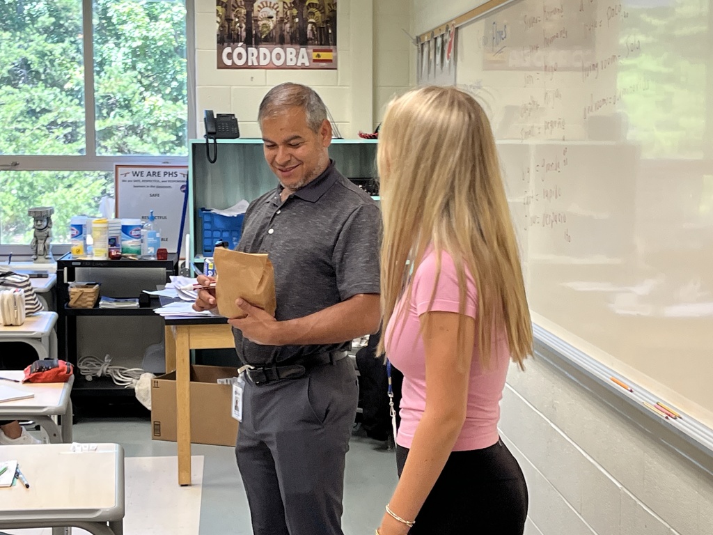 A student delivers a goodie bag to a teacher. 
