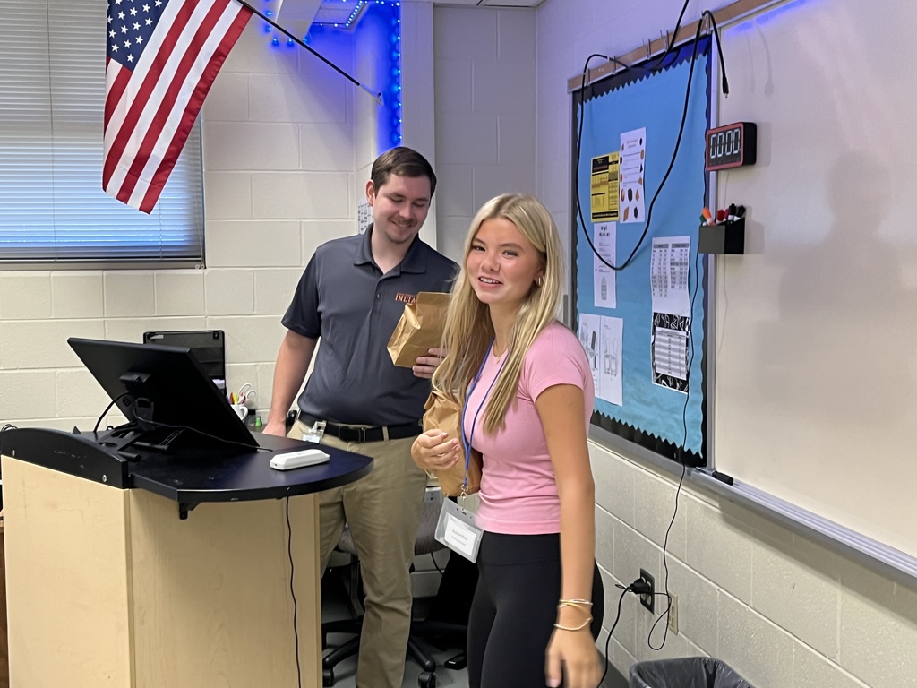 A student delivers a goodie bag to a teacher. 