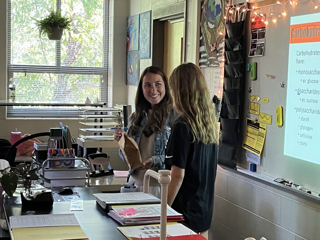 A student delivers a goodie bag to a teacher. 