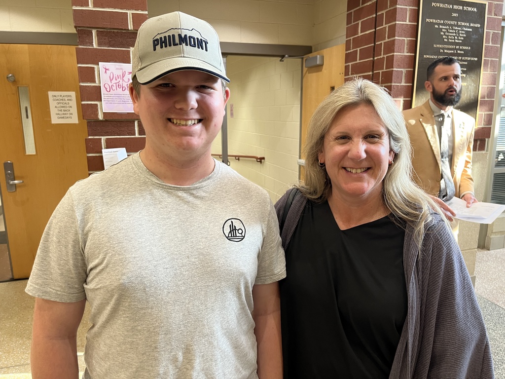 An adult and a  student pose for a photo on a back-to-school night.