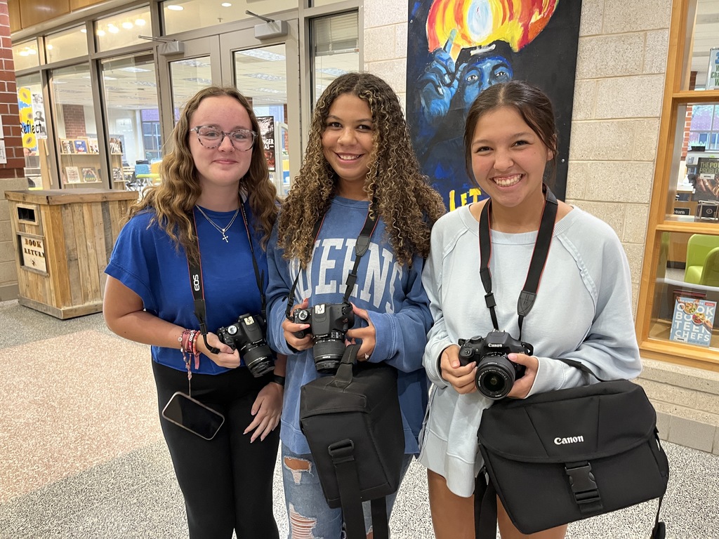 Three students pose for a photo on a back-to-school night.