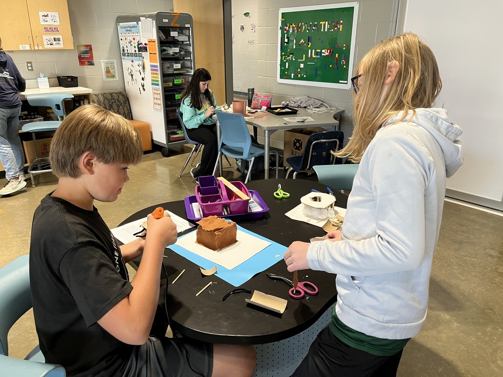 Students in an classroom build indigenous homes. 