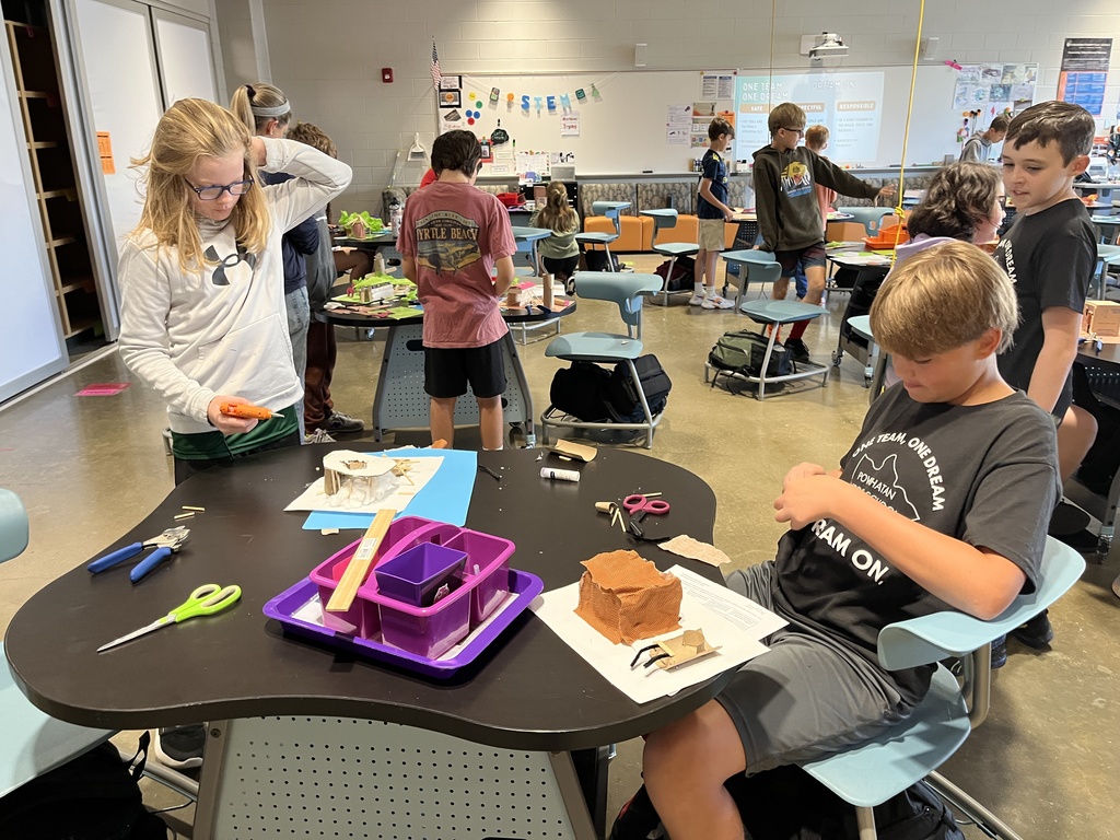 Students in an classroom build indigenous homes. 