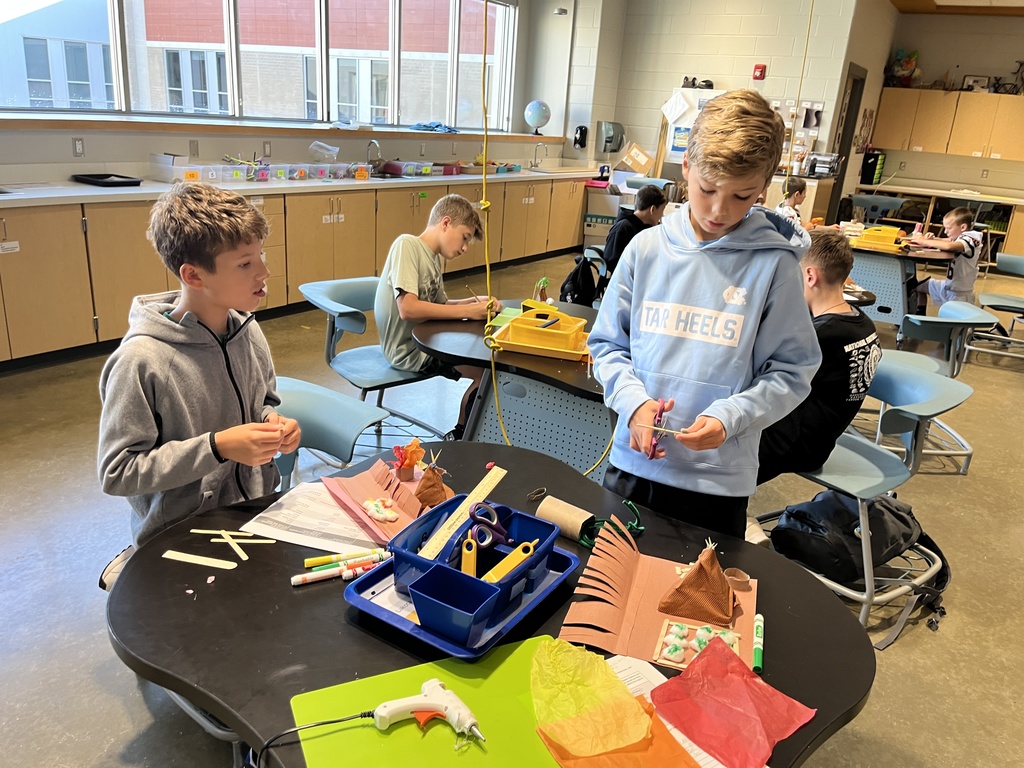 Students in an classroom build indigenous homes. 