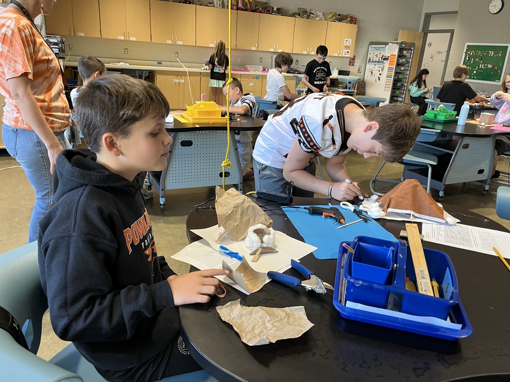 Students in an classroom build indigenous homes. 