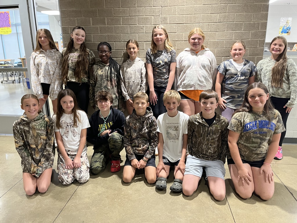 A large group of students pose for a photo showing off attire for Camo Day. 