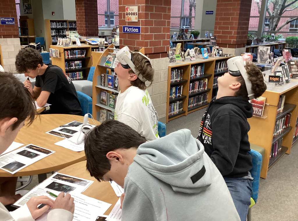 Students in a library participate in a constellation station project.