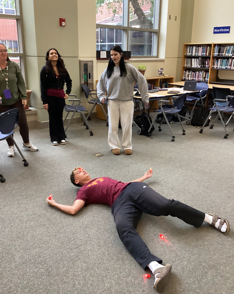 Students in a library participate in a constellation station project.