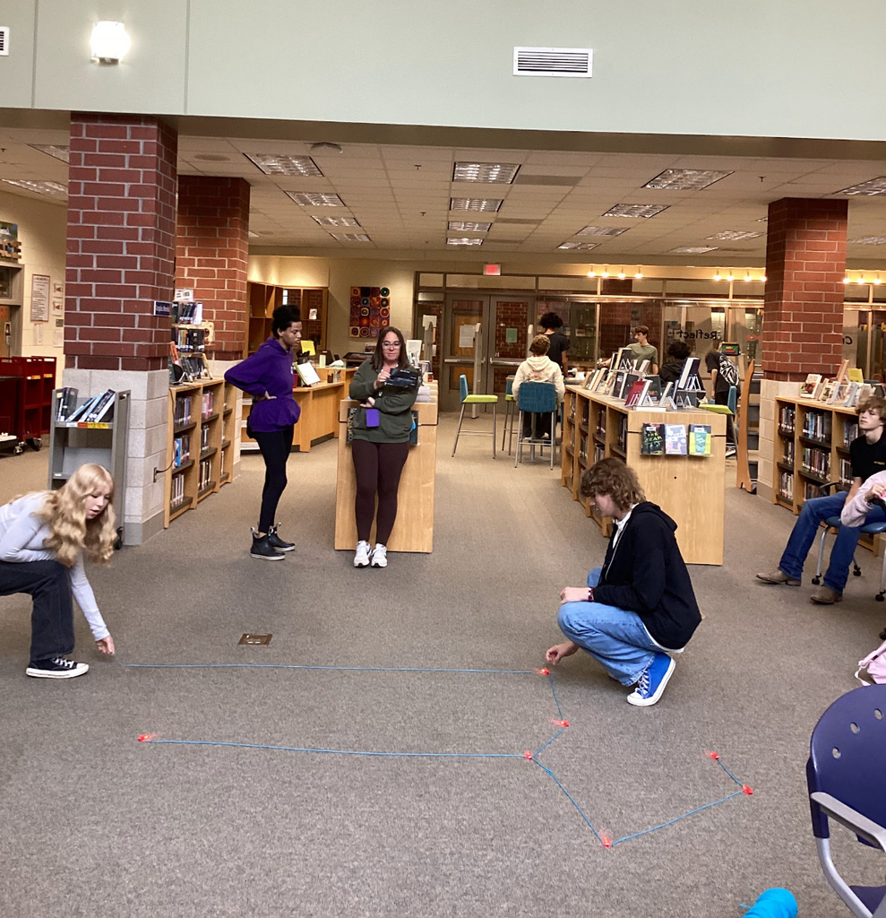 Students in a library participate in a constellation station project.