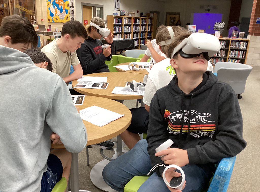 Students in a library participate in a constellation station project.