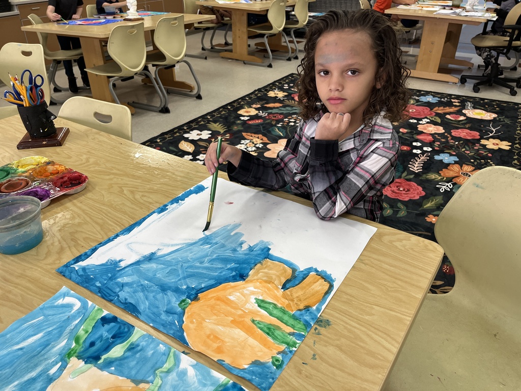 A child paints a fish painting in art class. 