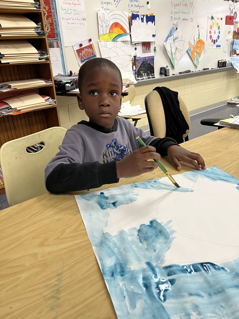 A child paints a fish painting in art class. 