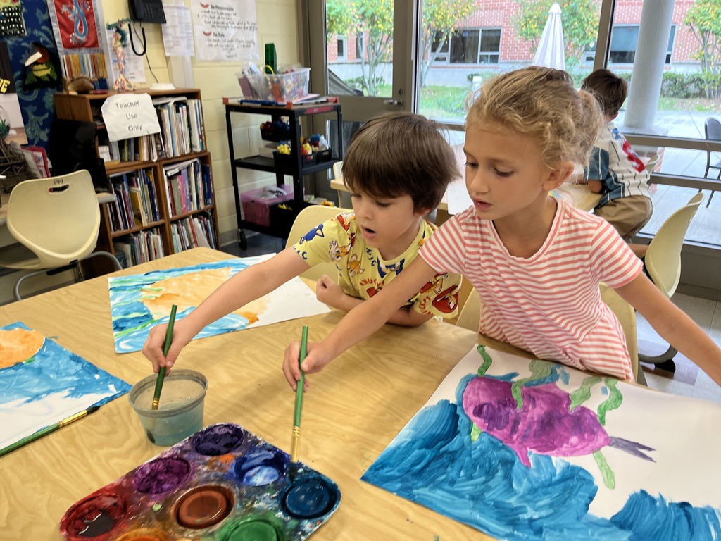 Children paint fish paintings in art class. 