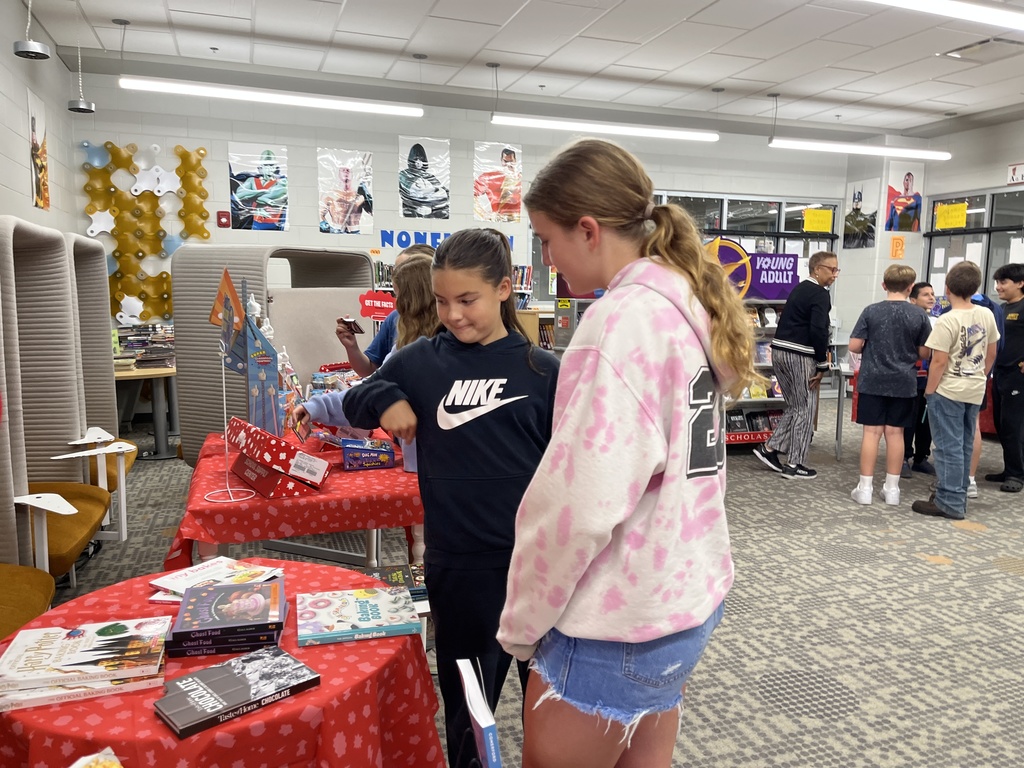 Students shop at a middle school book fair. 