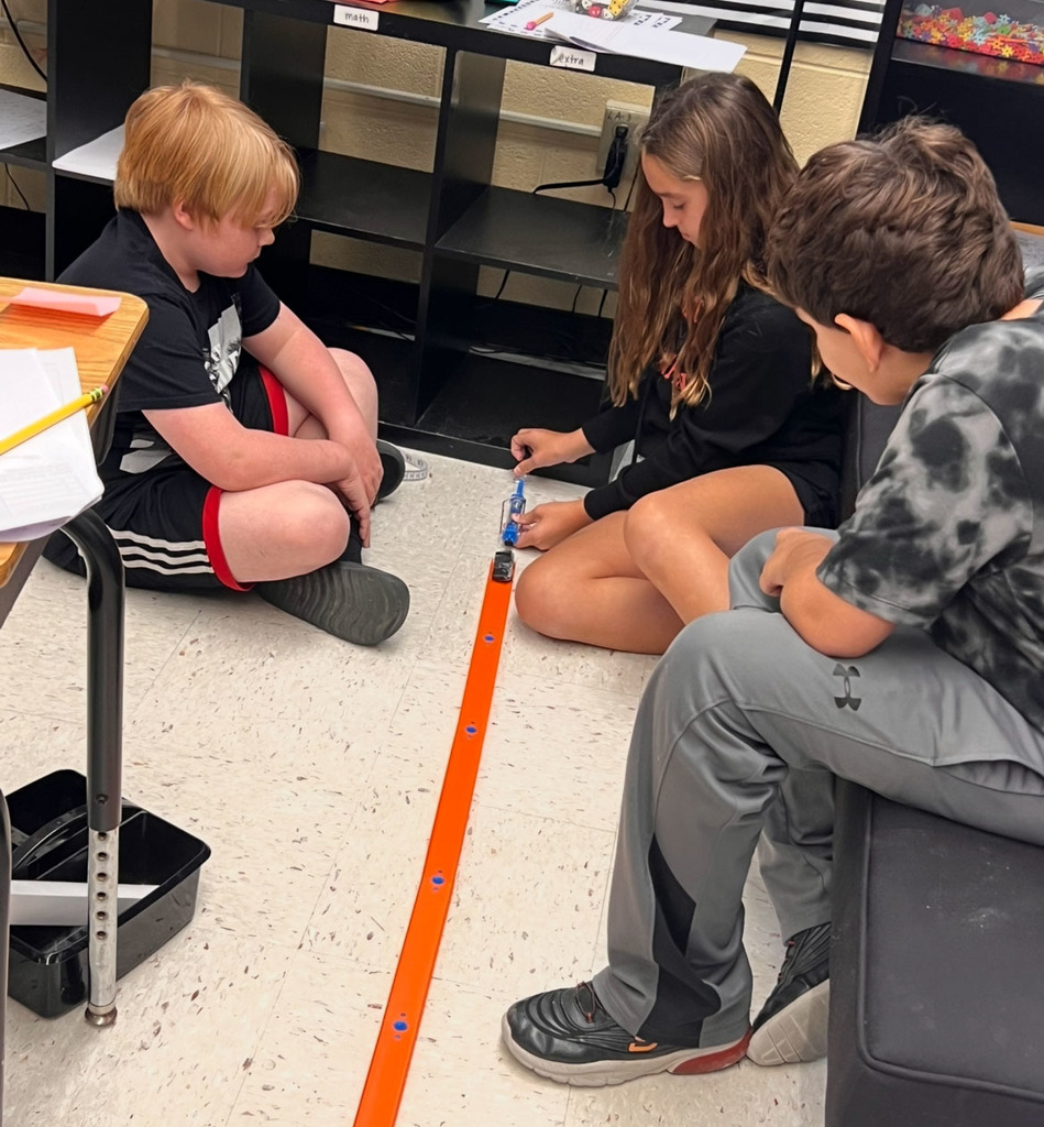 Students conduct an experiment to investigate whether mass affects motion.