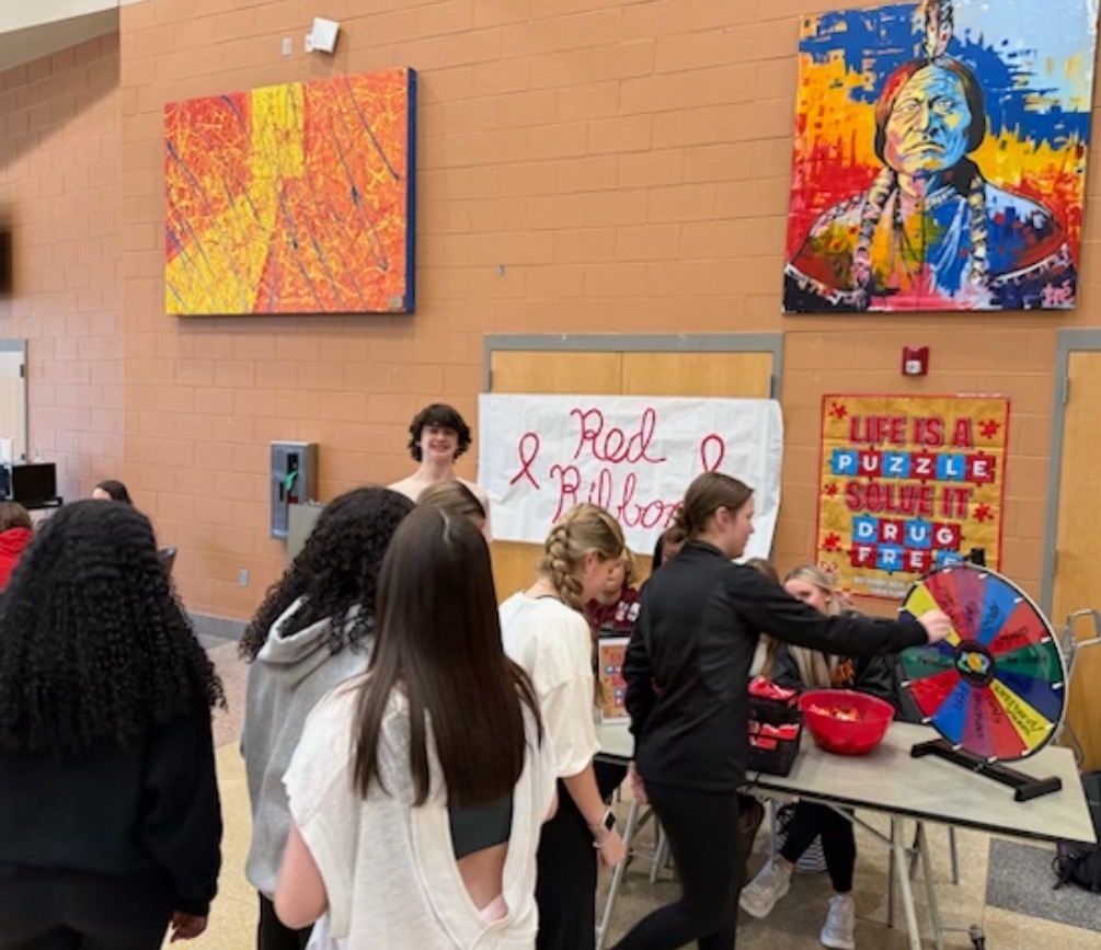 Students stand in line to spin a prize wheel.