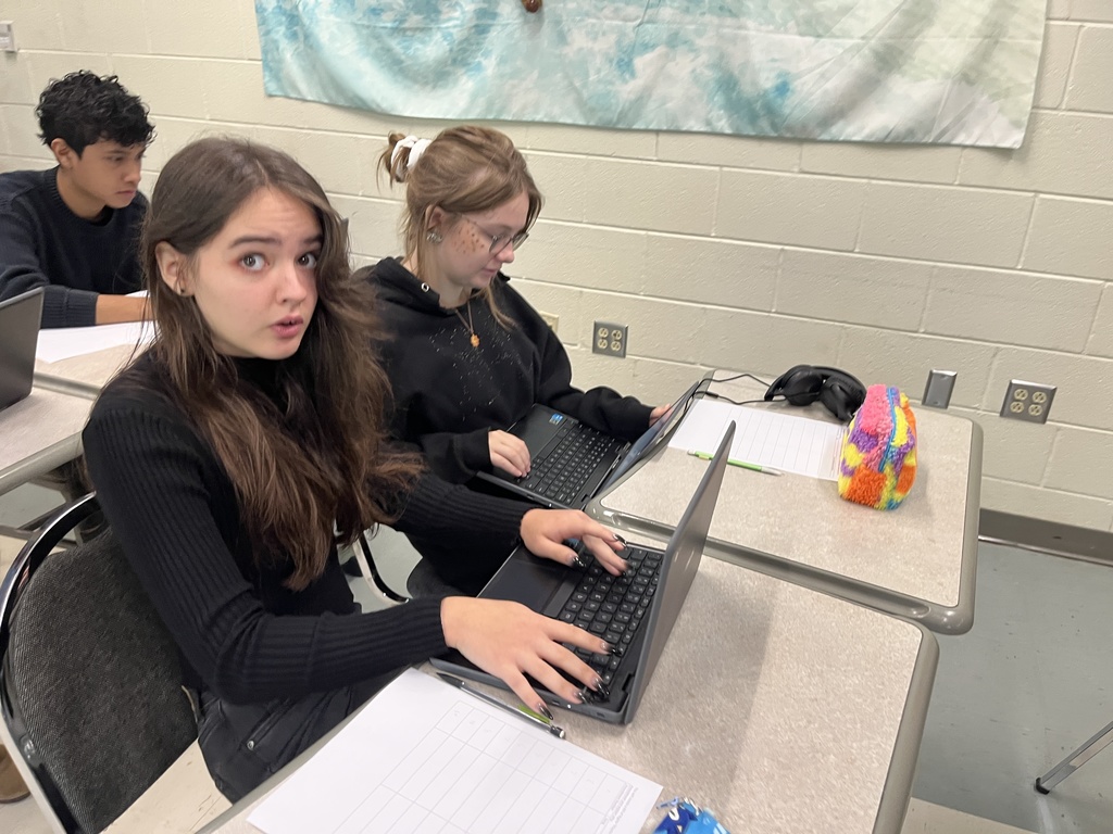 Students work in groups on a project about the Bill of RIghts. 