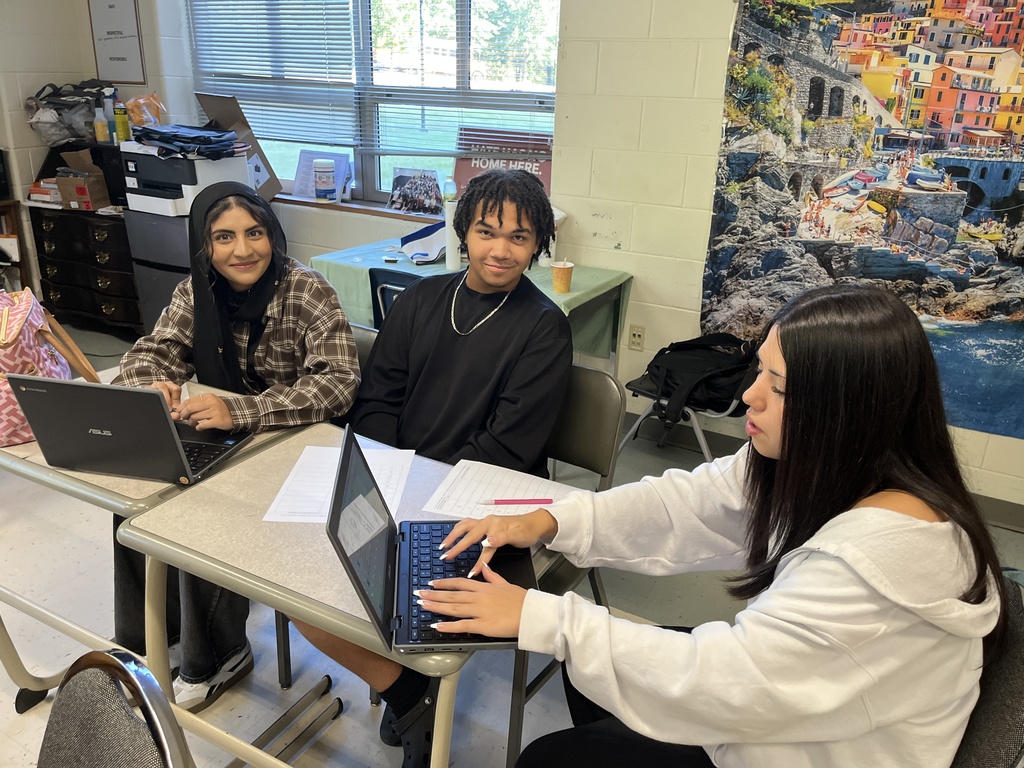 Students work in groups on a project about the Bill of RIghts. 