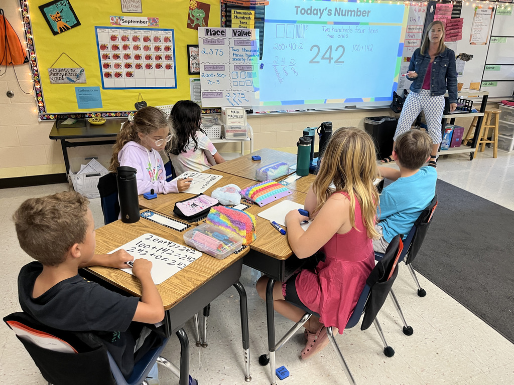Students in a class explore all the different ways to represent a number with their teacher.