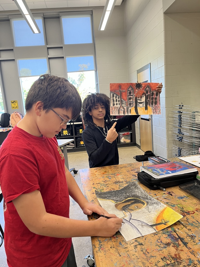 Students in art class work work on portrait assignment.