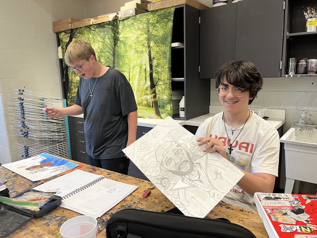 Students in art class work work on portrait assignment.