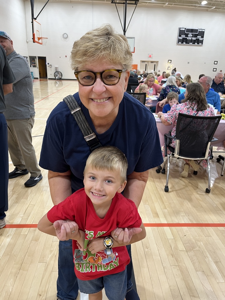 One adult and one child pose for a photo at a grandparents breakfast. 