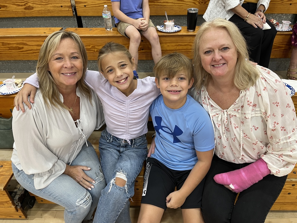 Two adults and two children pose for a photo at a grandparents breakfast. 