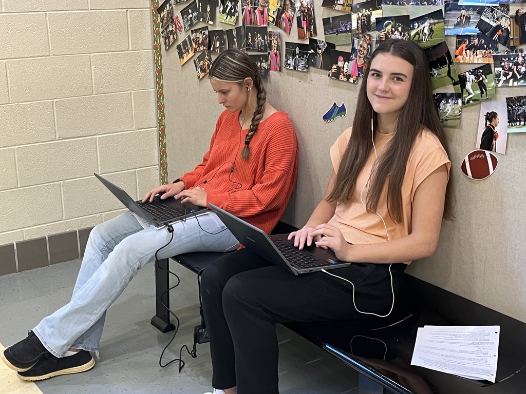 Students work in groups on a practical law assignment in a school hallway.