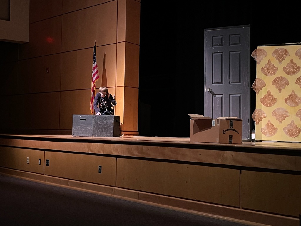 A student performs in a one-act play in a high school theater.
