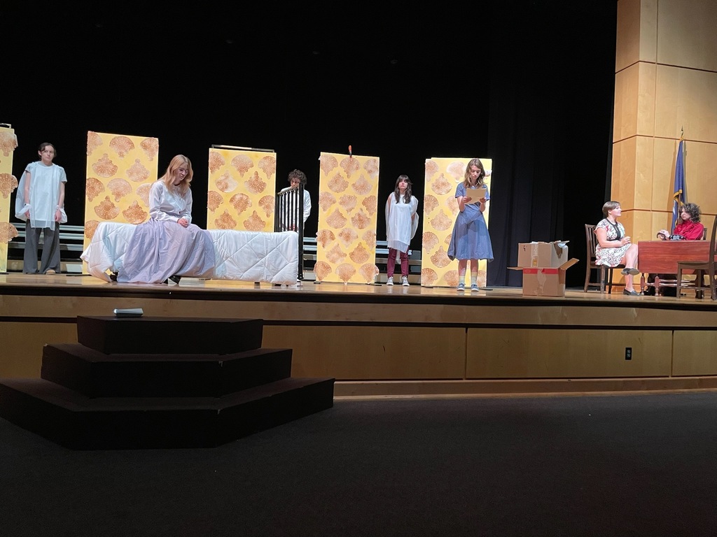 Students perform in a one-act play in a high school theater.