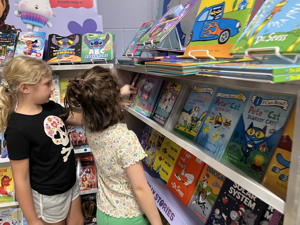Students search through merchandise at a school book fair. 