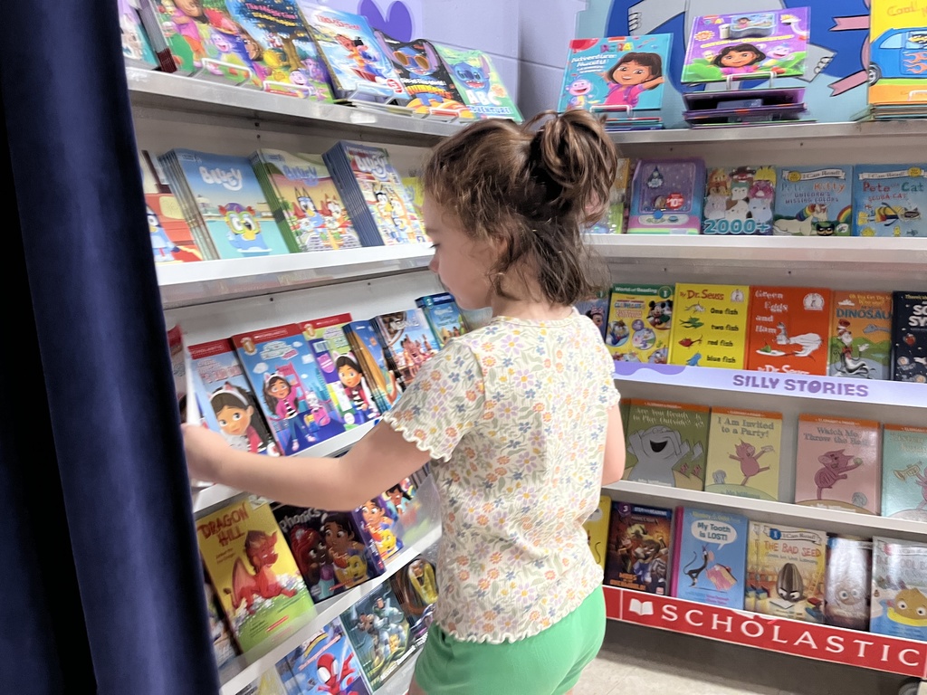 A student searches through merchandise at a school book fair. 