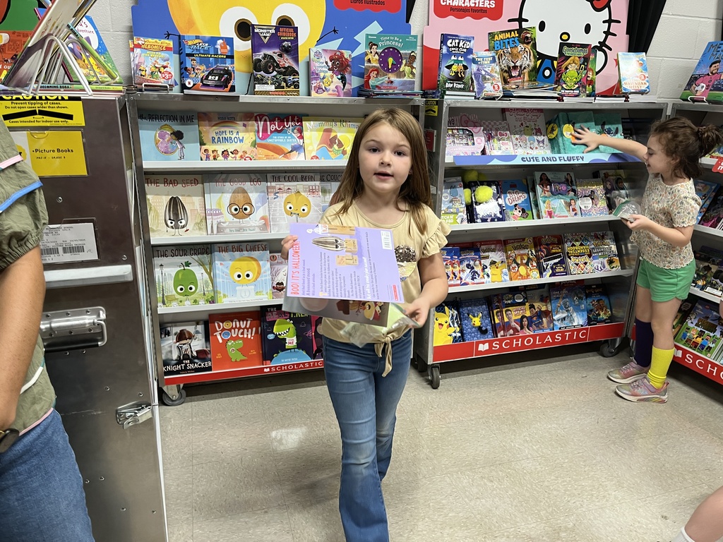 Students search through merchandise at a school book fair. 