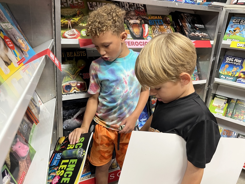 Students search through merchandise at a school book fair. 