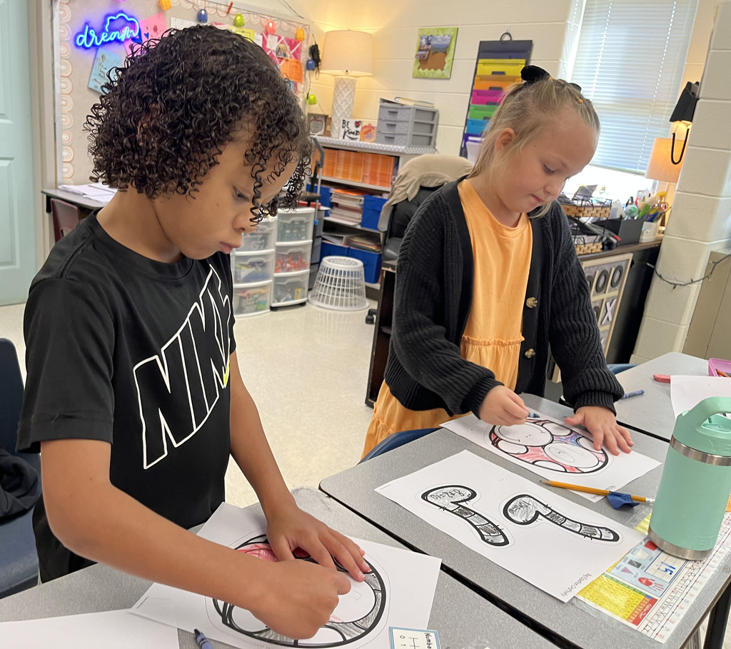 Children work on a math bug activity. 
