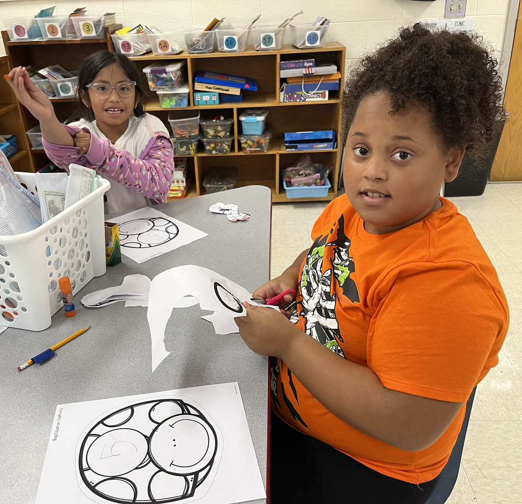 Children work on a math bug activity. 